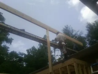 Carpenter setting a ridge beam over a new addition frame — Ice Dam Removal by Roofing Brothers in White Stone