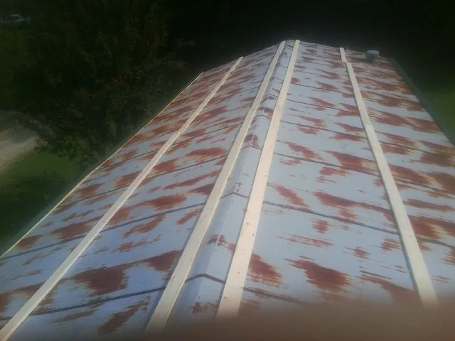 Rusted metal roof panels with new wood purlins before replacement — Storm Damage Roof Repair in White Stone by Roofing Brothers