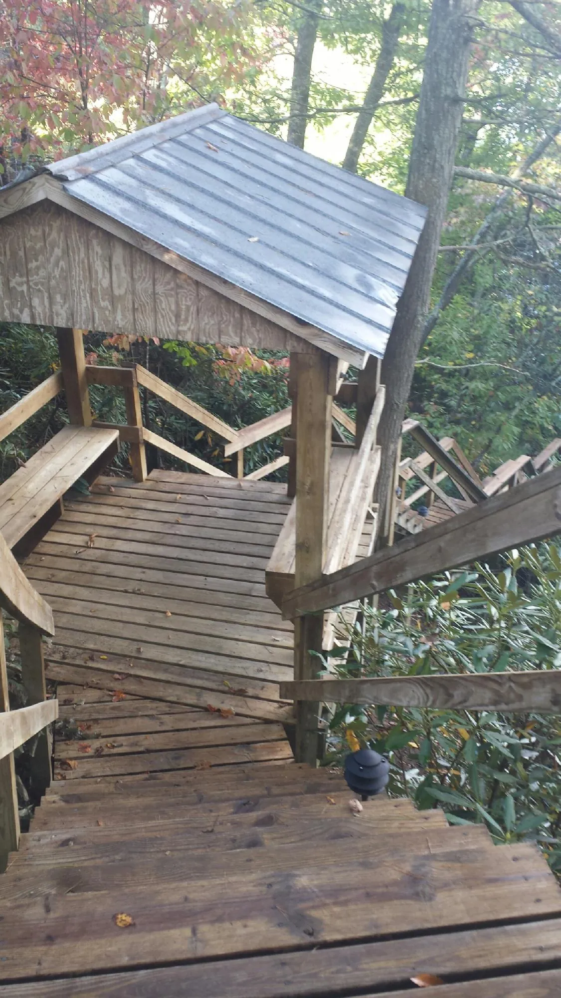Metal roofed shelter over wooden steps on a wooded walkway — Skylight Repair & Installation work by our crew in White Stone