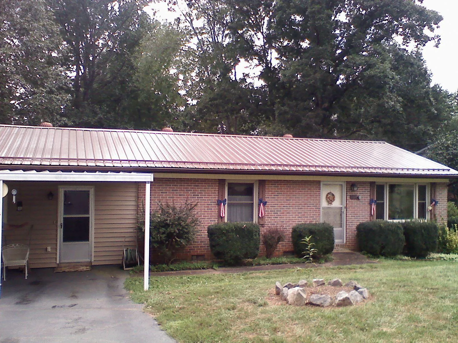 Bronze metal roof and carport on a brick ranch home — Roof Repair work by our crew in White Stone