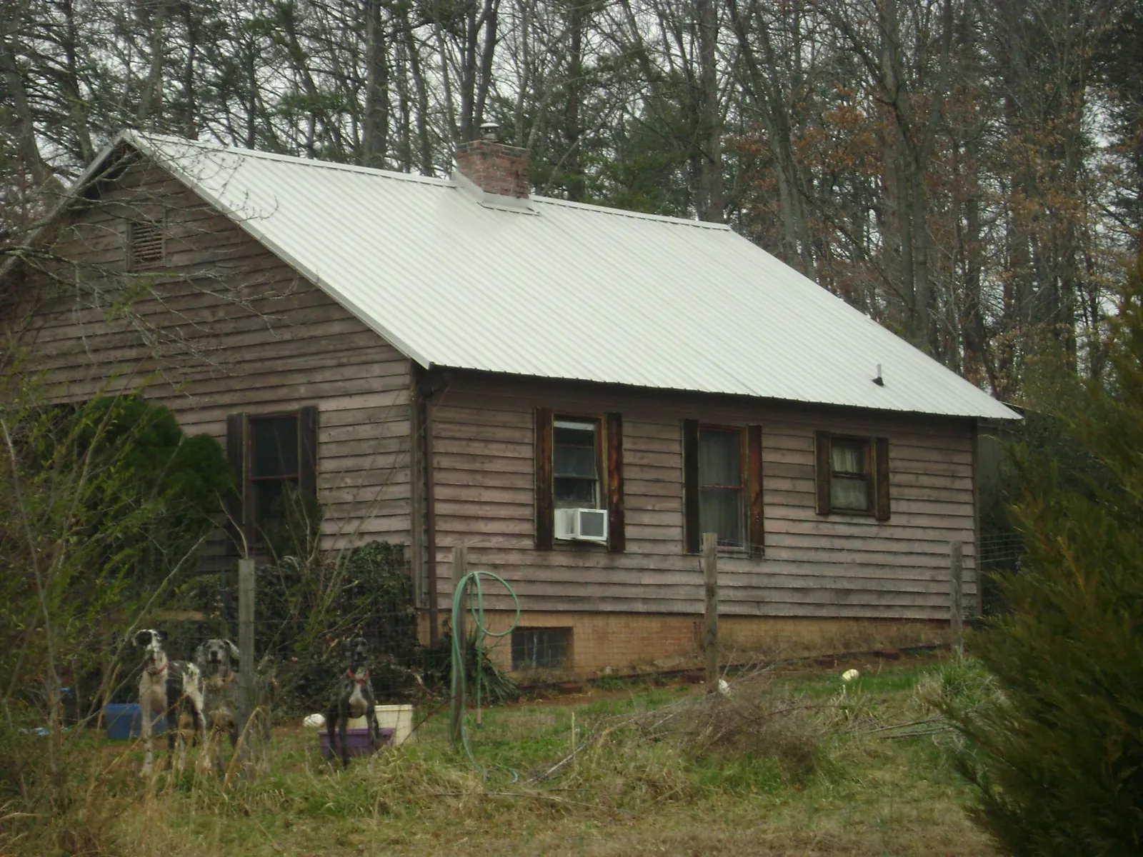White metal roof on an old wood sided farmhouse, from a Metal Roof Installation job in White Stone